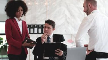 Yeni evrak projeleri hakkında fikir alışverişinde bulunan iş adamları birlikte çalışarak başarı stratejisi planlıyorlar. Çok ırklı iş arkadaşları ofis toplantılarında pazarlama konusunda fikir alışverişinde bulunuyorlar..