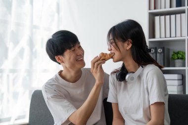 Onu kruvasanla besleyen kız arkadaşıyla eğlenen mutlu bir adam..