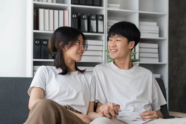 快乐的年轻的亚洲夫妇在舒适的沙发上放松 拥抱对方 享受周末的家 — 图库照片