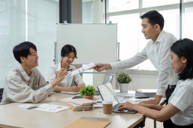 İş adamları yatırım grafiklerini analiz etmeyi, başarılı takım çalışmalarının sonuçlarını gösteren grafikleri ve grafikleri klavye yazmayı, grafik planlarını analiz etmeyi tartışıyor..