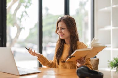 Kız evde dizüstü bilgisayar kullanıyor, ekran başında sohbet ediyor, e-posta yazıyor. İnternette görüntülü sohbet görüşmesi yapan genç bir kadın. Evden öğrenme işi.