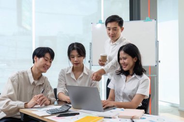 Gülümseyen meslektaşlar toplantı odasında toplanmış mali istatistikleri tartışıyorlar. Mutlu iş arkadaşları ofis toplantılarında ve takım çalışması konseptinde iş birliği yaparken eğleniyorlar..