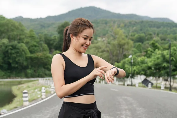 亚洲女人准备带着漂亮的手表跑步检查你在公园里跑步的心率 健康积极的体育生活方式概念 — 图库照片
