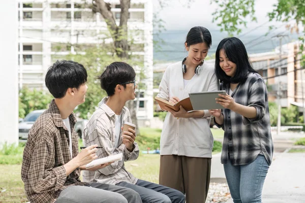 Studenci Siedzący Razem Przy Stole Książkami Laptopem Tabletem Szczęśliwi Młodzi — Zdjęcie stockowe