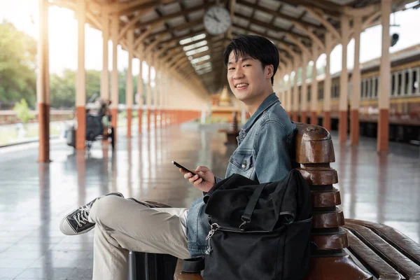 Gezgin Genç Asyalı Adam Tren Istasyonunda Cep Telefonu Rezervasyonu Yapıyor — Stok fotoğraf