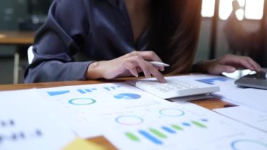 İş yerindeki belgelerle çalışan genç kadın muhasebeciyi kapatın. Hesaplama mali raporu. Hesap makinesi kullanıyor. Bayan işçi girişimci evrak işleriyle meşguldür..