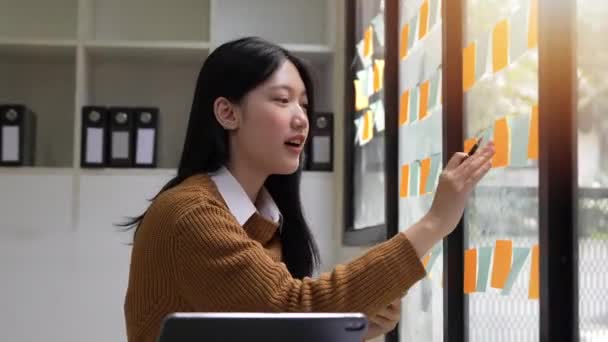 Νεαρή Ασιάτισσα Επιχειρηματίας Που Εργάζεται Σχέδιο Έργου Χρησιμοποιώντας Αυτοκόλλητα Σημειώματα — Αρχείο Βίντεο