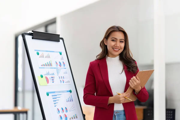 stock image Female office worker working on her presentation standing near white board the profit report finance.