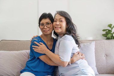 Hayatın en büyük zevklerinden biri, eski iyi bir dost. Evde birbirini kucaklayan iki mutlu yaşlı kadının fotoğrafı..