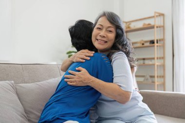 Hayatın en büyük zevklerinden biri, eski iyi bir dost. Evde birbirini kucaklayan iki mutlu yaşlı kadının fotoğrafı..