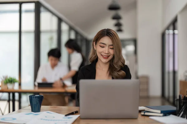 ビジネスの若い女性幸せな陽気なかわいいビジネスの女性は ラップトップコンピュータを使用してオフィスに座る — ストック写真