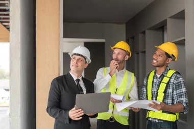 Professional construction engineers team using blueprint of project plan brainstorming and working together at construction building, Architecture and building construction concept.