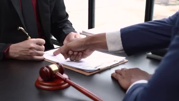 正義と法の握手の概念を扱う 弁護士は 法律事務所で弁護士会や法律事務所との間で締結された契約をクライアントに提示します — ストック動画