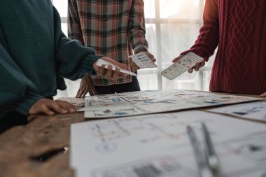 UX geliştiricisi ve ui tasarımcısı modern ofiste mobil uygulama arayüzü kablo tasarımı hakkında beyin fırtınası yapıyorlar.