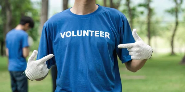 身着印有义工信息的T恤衫的年轻人志愿工作近身 — 图库照片