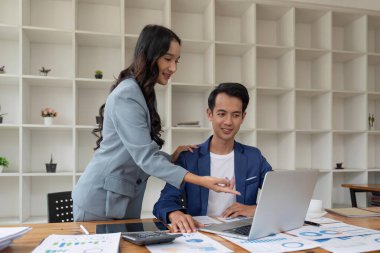 Ofiste birlikte çalışan mutlu iş adamları bilgisayar ve tablet kullanırken şirketin mali ve vergilerini analiz ediyorlar..