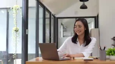 Bilgisayarla çalışan Asyalı bir iş kadını ve ofiste evraklar. Muhasebe finansal konsepti.