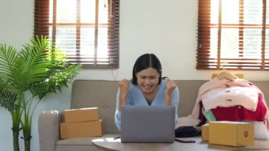 Başarılı bir kadın evde online ürün satmak için dizüstü bilgisayar kullanıyor..