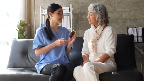 医師は高齢患者の女性に薬をお勧めします — ストック動画