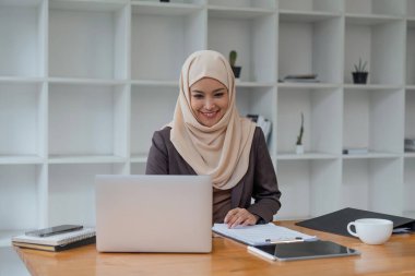 bilgisayarda Office çalışma odaklı Müslüman işkadını portresi.