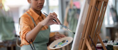 Resim stüdyosundaki tuvale resim yapan Afrikalı Amerikalı erkek ressamı yakından çek. Bir resim stüdyosunda yaratıcılık ve ilham.