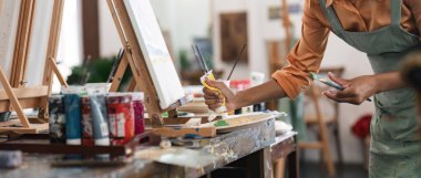 Güzel Afro-Amerikan ve otantik genç kadın ressamın yakın portresi sanat eseri yaratıyor. Kişisel yaratıcı proje için ayrıntılı çalışma.