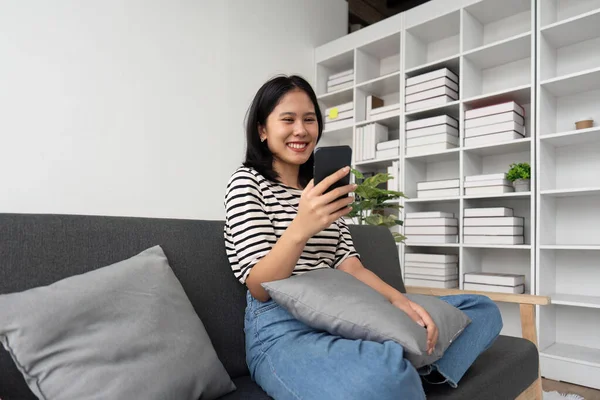 Bela Mulher Asiática Sentar Sofá Mão Segurando Telefone Celular Conversando — Fotografia de Stock