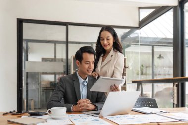 Yeni başlatılan proje fikir sunumunda çalışan iş adamları, ofisteki tablette planlama analizi.