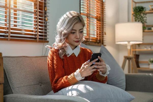 Mutlu Rahat Genç Asyalı Kadın Koltukta Oturuyor Cep Telefonu Kullanıyor — Stok fotoğraf