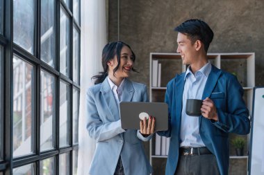 Akıllı iş adamları iş yerinde konuşurken tabletle birlikte çalışıyorlar..