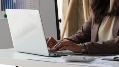 Ofisinde dizüstü bilgisayarla çalışan bir iş kadınının elleri. Bilgisayarında daktilo eden bir girişimci kadın. Küçük bir işletmenin başarısı sıkı çalışma ve kendini adamayı gerektirir..