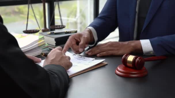 正義と法の握手の概念を扱う 弁護士は 法律事務所で弁護士会や法律事務所との間で締結された契約をクライアントに提示します — ストック動画
