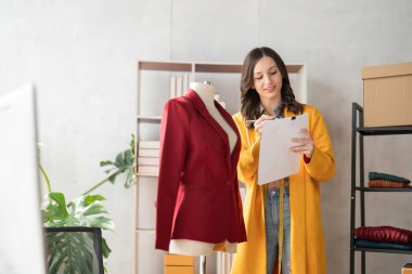 Kadın moda tasarımcısı yeni moda kıyafet koleksiyonu tasarlıyor. Moda tasarımcısı stüdyoda çalışıyor..