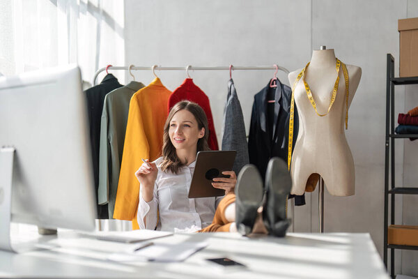 Дизайнер женской одежды разрабатывает новую модную коллекцию одежды. Модный дизайнер работает в студии.