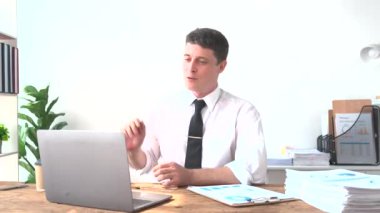 Genç mutlu iş adamı modern ofisteki bilgisayar kullanarak Webinar video eğitiminde konuşuyor. İş adamı iş görüşmesinde, çevrimiçi takımla konuşuyor. Uzak bir çevrimiçi çalışma konsepti.