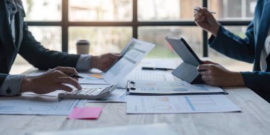 İş ekibi, modern dizüstü bilgisayar ve dijital tabletle gelir tablolarını ve grafiklerini analiz ediyor. Kapatın. İş analizi ve strateji kavramı.