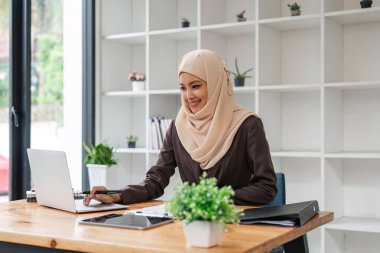 bilgisayarda Office çalışma odaklı Müslüman işkadını portresi.