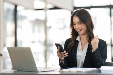 Başarılı ve heyecan verici bir iş kadını. Genç bayan iş yerinde akıllı telefonuyla kazanacağı için heyecanlı..