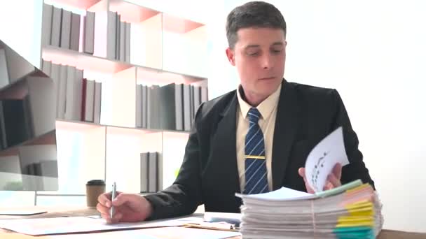 Bilgisayarda Çalışan Odaklanmış Bir Adamı Ofis Masasında Oturmuş Notlar Alıyor — Stok video