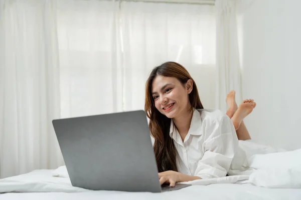 Piękna Szczęśliwa Azjatka Leżąca Łóżku Zrelaksowana Patrząca Ekran Laptopa Dziewczyna — Zdjęcie stockowe