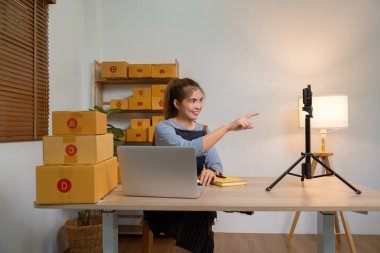 Dükkanında online e-ticaret yapan genç bir kadın canlı yayın yapıyor..