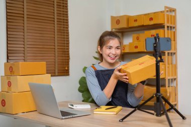 Dükkanında online e-ticaret yapan genç bir kadın canlı yayın yapıyor..