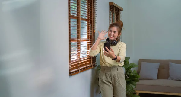 亚洲妇女正在使用手机在家里愉快地进行无线通信视频通话 — 图库照片