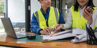 Ofiste planları olan iki mühendis, mimari plan için işyerinde teftiş, inşaat projesi, iş inşaatı.