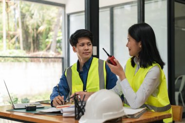 İki genç adam ve kadın mühendis buluşuyor, çalışıyor, tartışıyor, plan yapıyor, tasarım yapıyor, fabrikanın inşaat alanının planlarını ölçüyorlar..