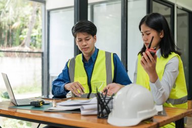 İki genç adam ve kadın mühendis buluşuyor, çalışıyor, tartışıyor, plan yapıyor, tasarım yapıyor, fabrikanın inşaat alanının planlarını ölçüyorlar..