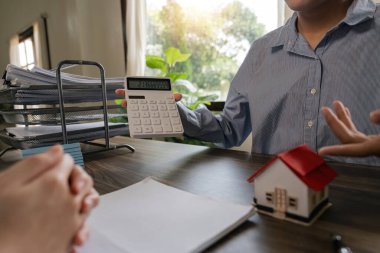 Emlakçı ev satın alma anlaşmasının şartları hakkında konuştu ve müşteriden sözleşmeyi yasal hale getirmek için belgeleri imzalamasını istedi, ev satışları ve ev sigortası kavramı.