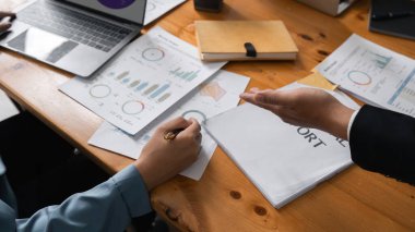 İş dünyası ekibi, başarılı takım çalışması ve iş toplantısı fikirlerini gösteren şirket toplantıları sırasında dizüstü bilgisayar ve grafik belgelerindeki mali iş finans raporlarını analiz eder..