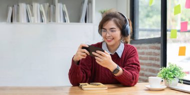 Evde kırmızı tişörtlü Asyalı öğrenciler online üniversite derslerine katılıyorlar..