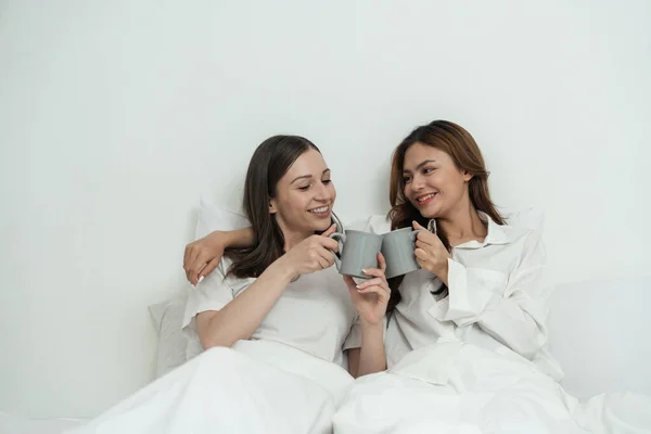 아시아의 쾌활한 행복한 친구는 침대에 커피를 가지고 라이프 스타일 레즈비언 — 스톡 사진